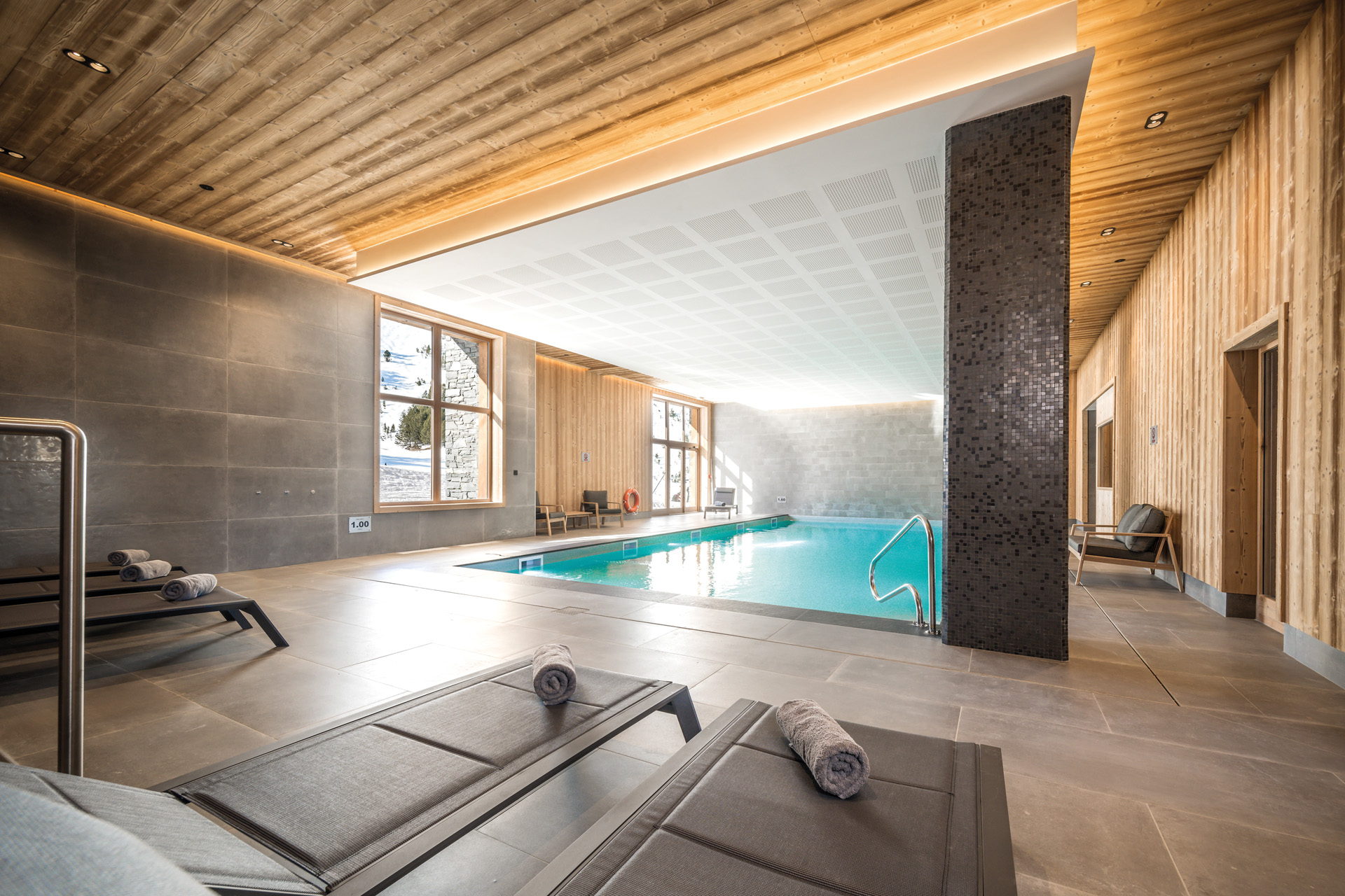 a small indoor swimming pool with sun loungers at Bear Lodge ski chalet