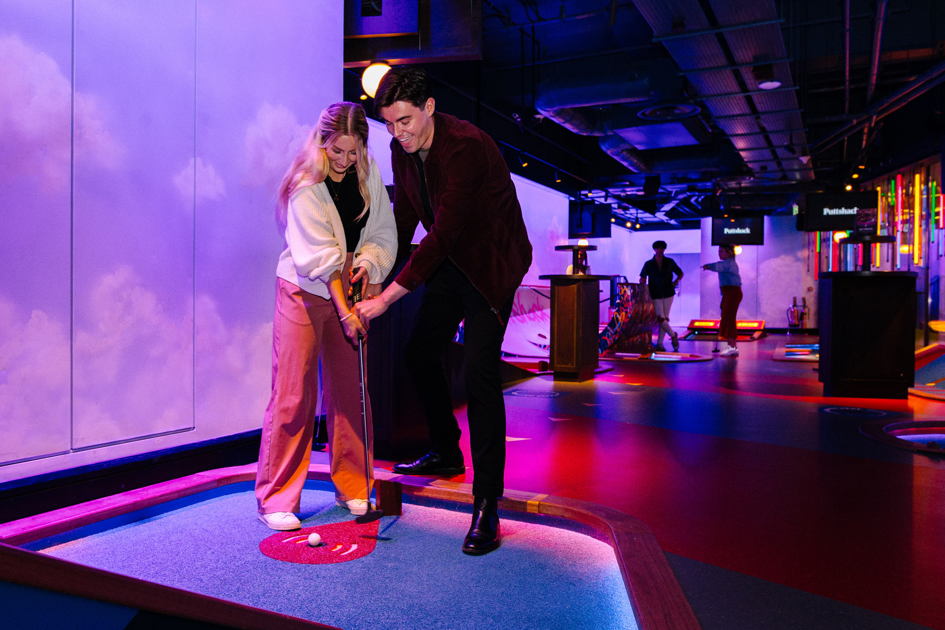 A couple playing golf at Puttshack