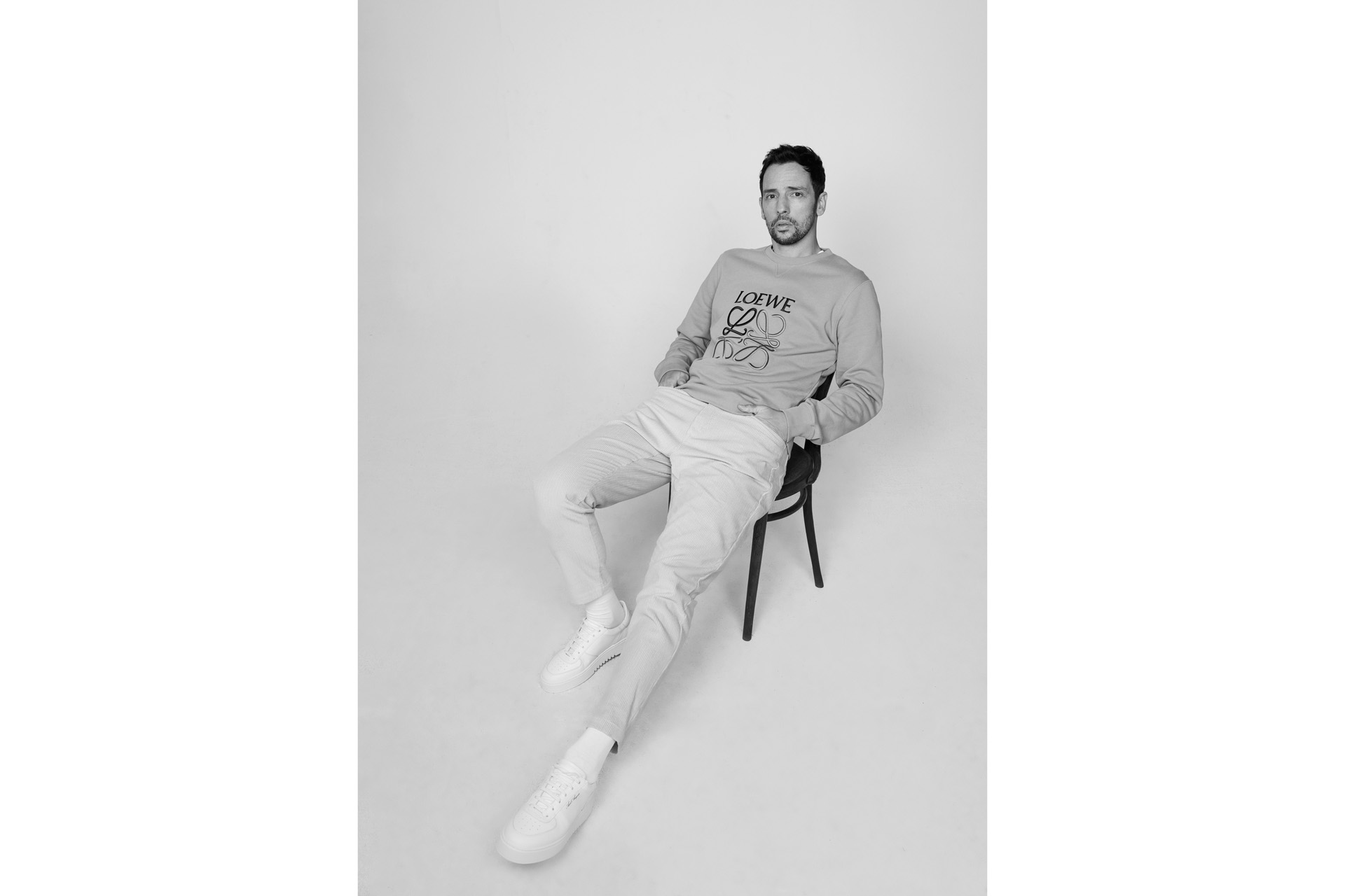 Ralf Little on a chair in black and white