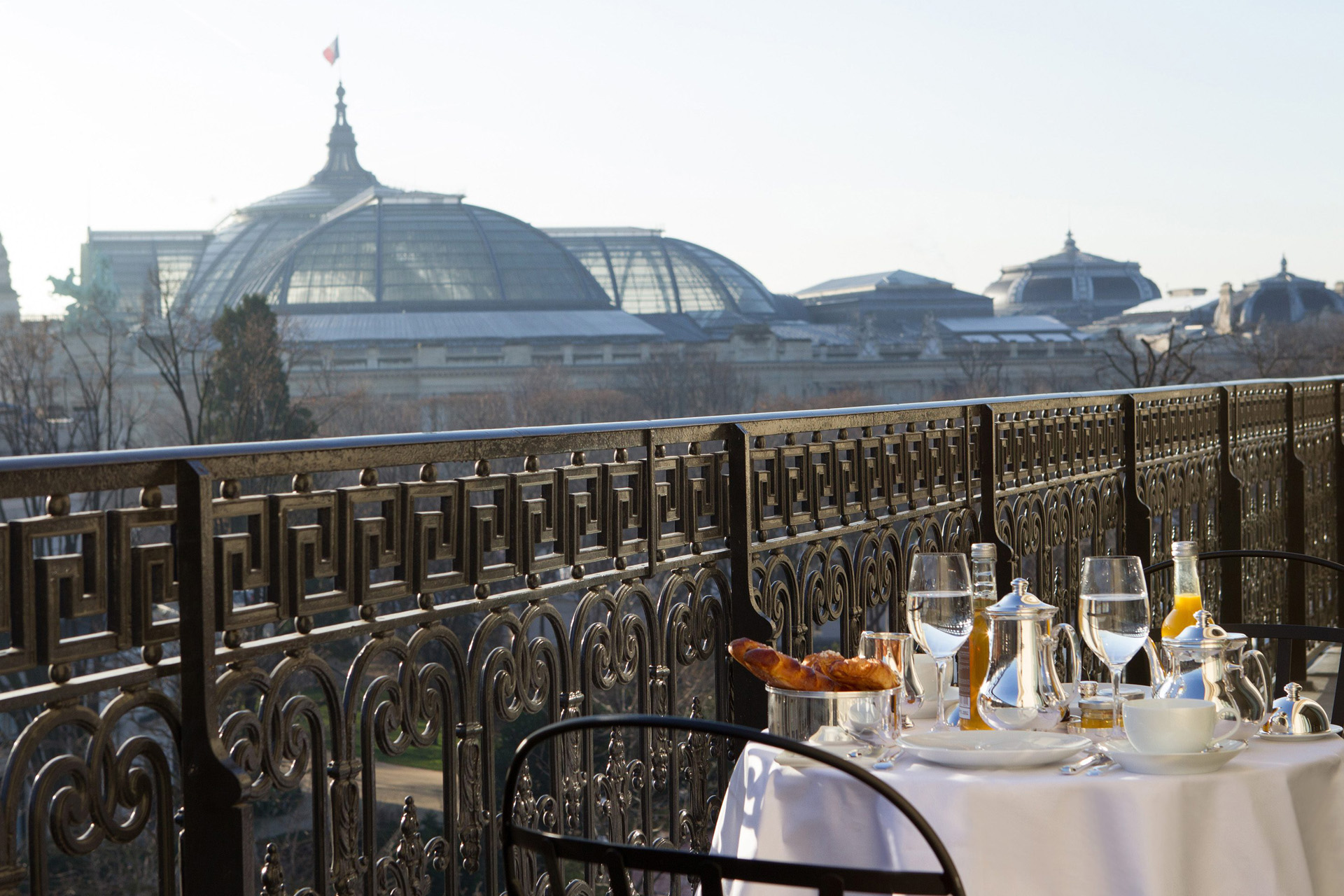 A balcony with a breakfast table at La Reserve Paris