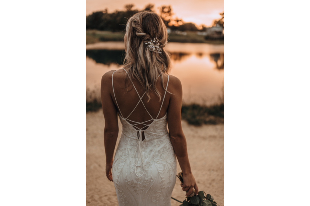 Woman in white dress by a river at sunset