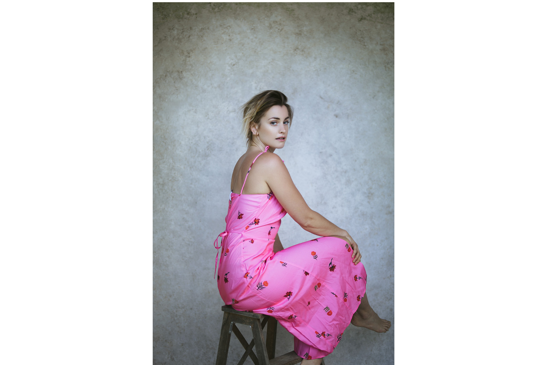 Stefanie on a chair in a pink dress
