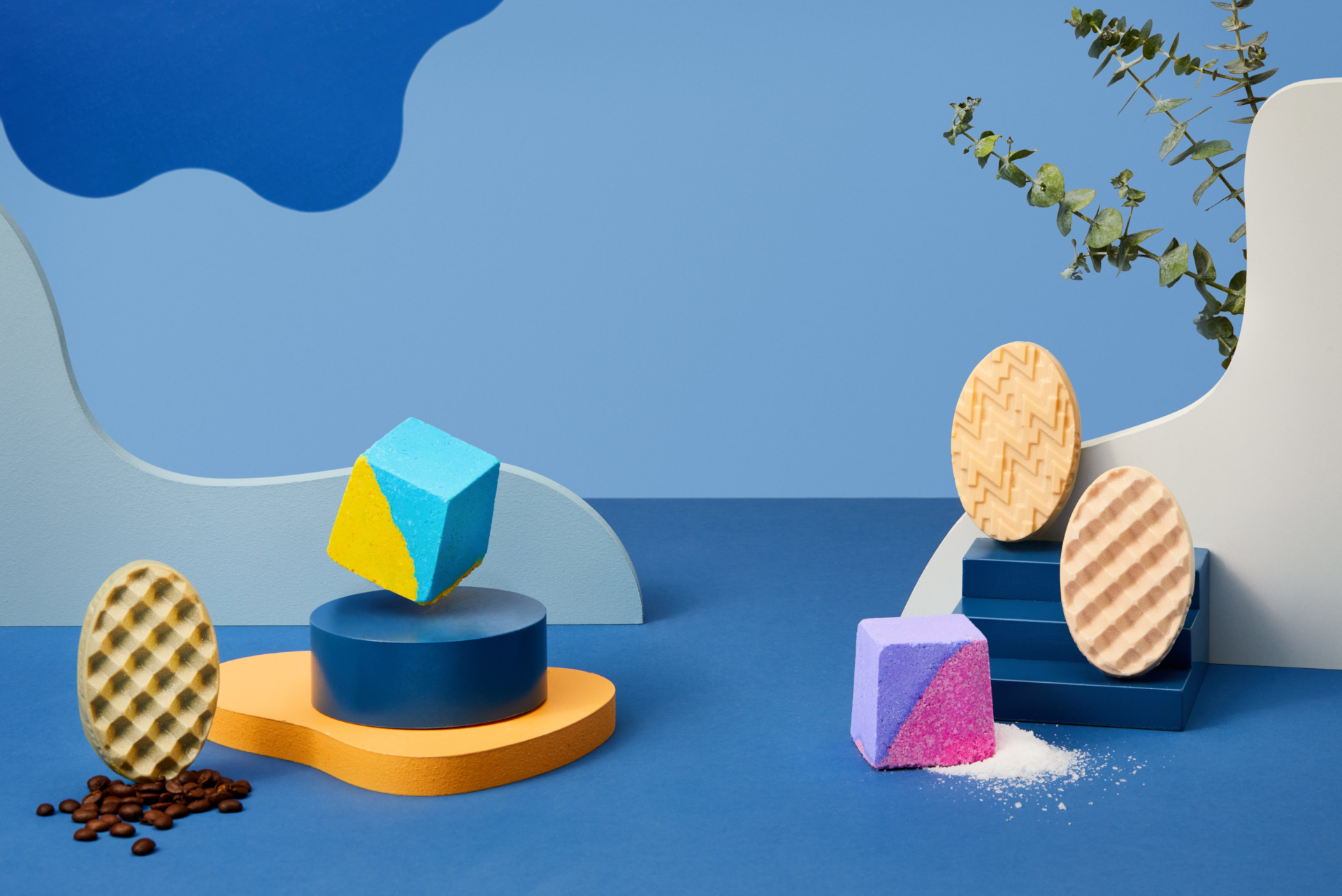 Epsom salt cubes and massage bars on blue wavy background