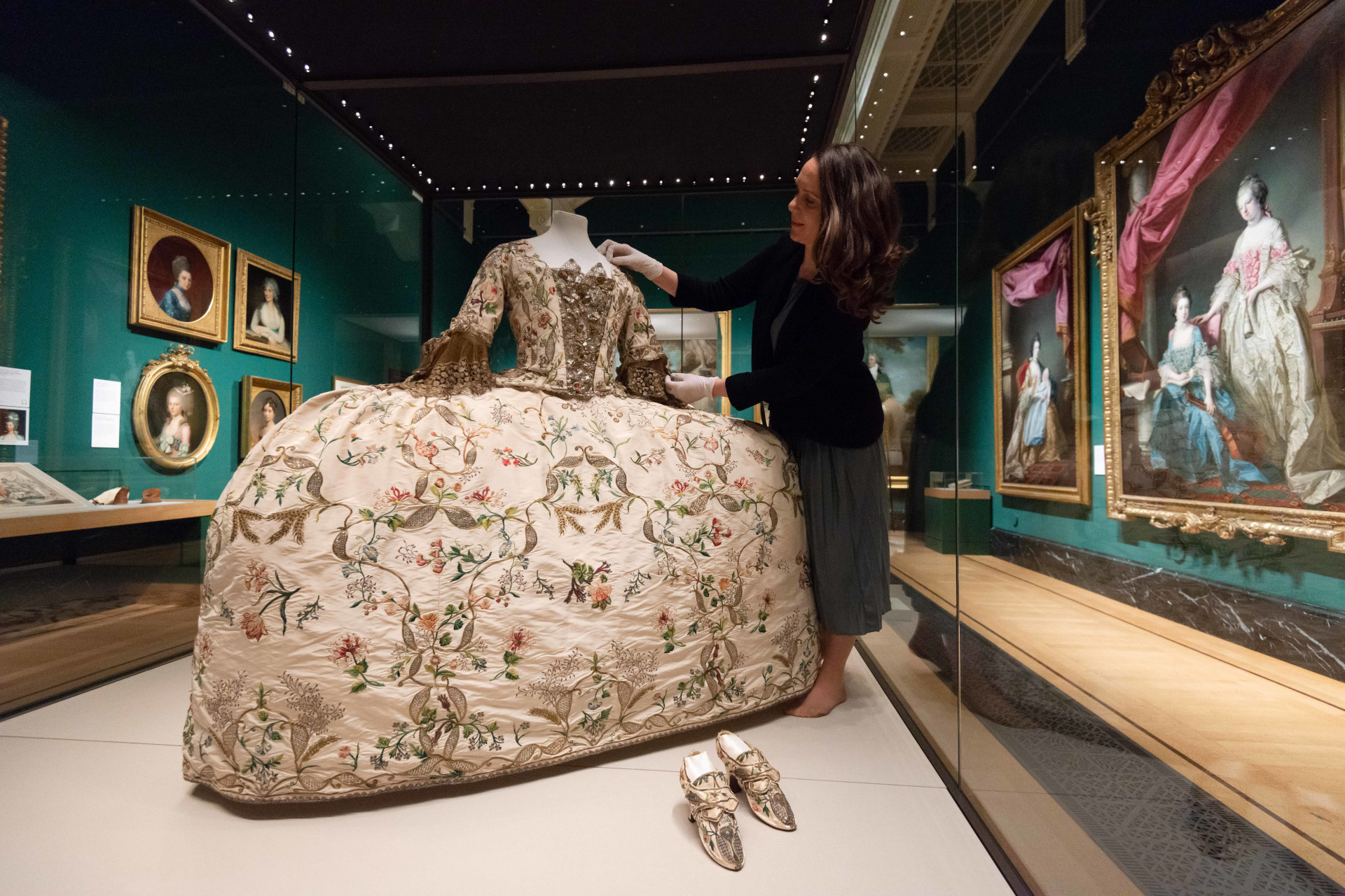Woman adjusting Georgian dress display