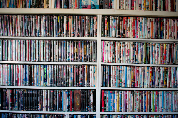 Movies in DVD cases on a shelf used as decoration for a pub