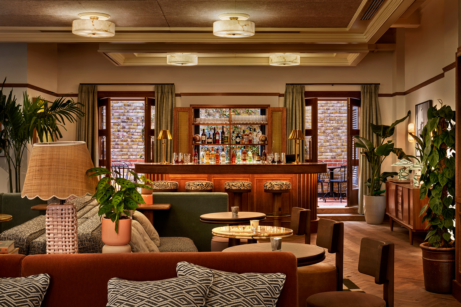 Bar with colour palette of green, grey and rust orange, with zebra-patterned bar stools.