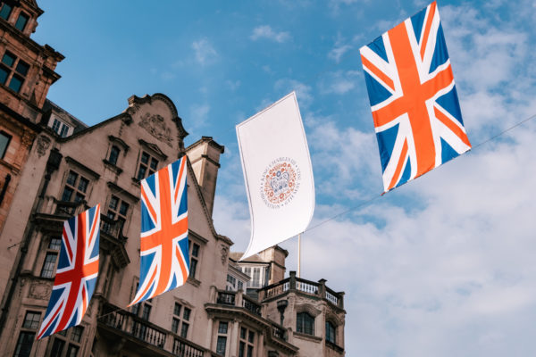 Union Jack and coronation emblem bunting on blue sky