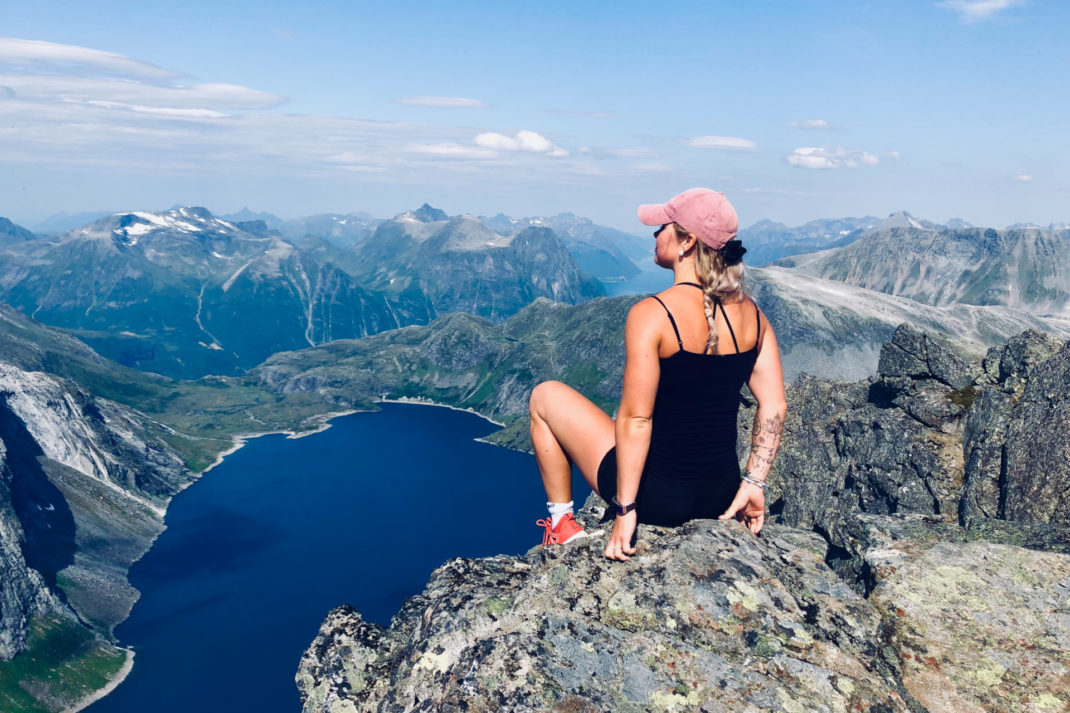 Woman sat on rock overlooking lake