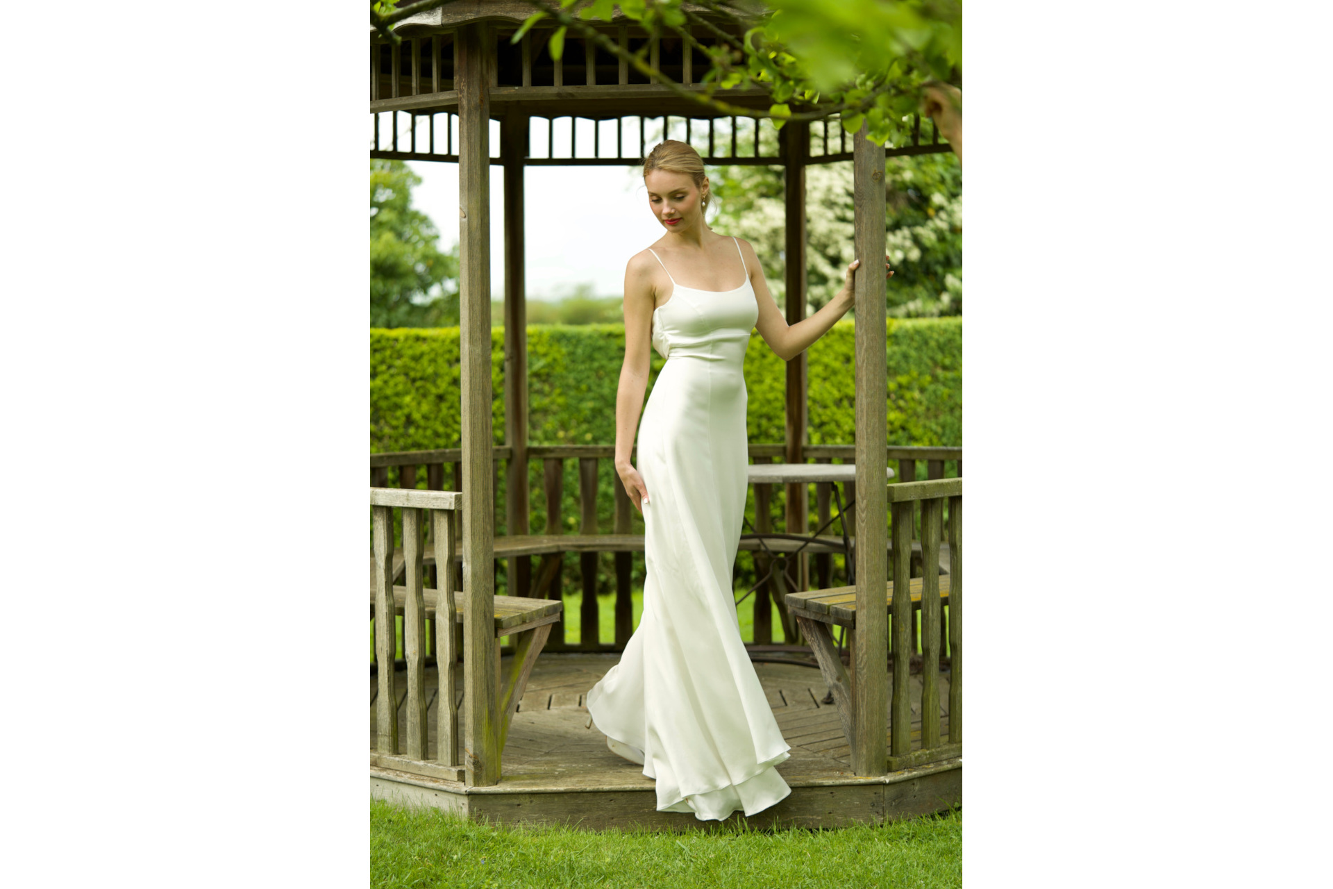 Woman in gazebo wearing white silky dress
