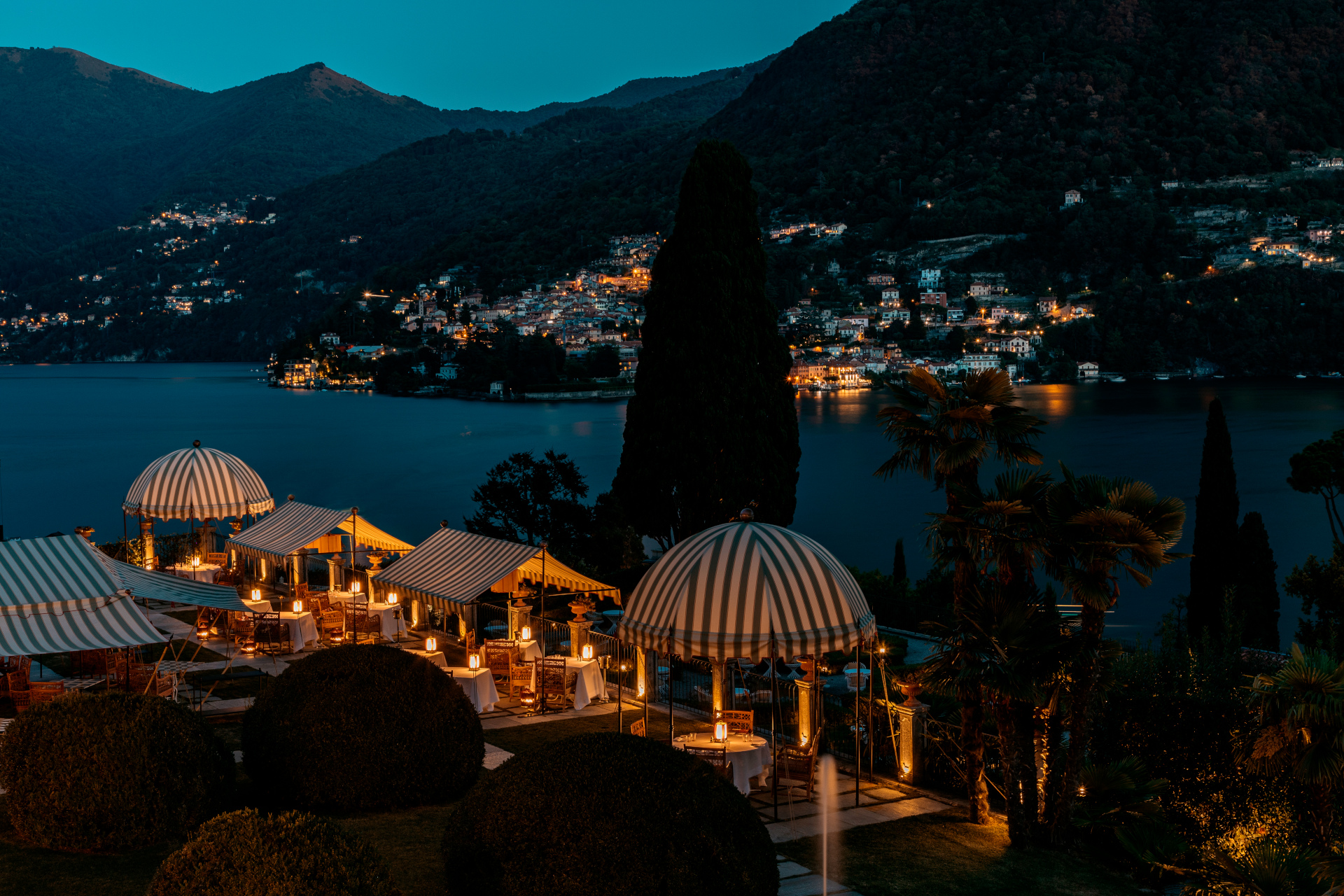 Night scene with lit up outdoor dining area near lake